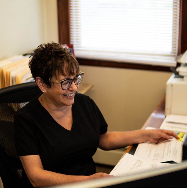 Smiling dental team member at reception desk