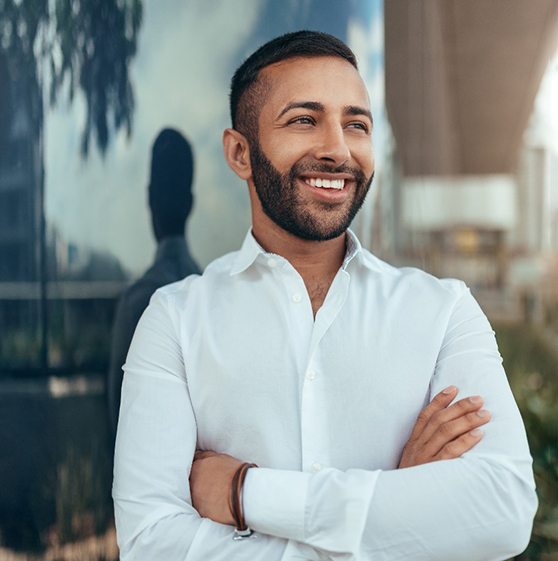 Man in white shirt smiling with arms crossed