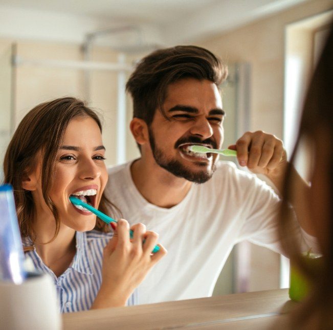 Man and woman brushing teeth