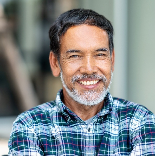 Man in blue plaid shirt smiling