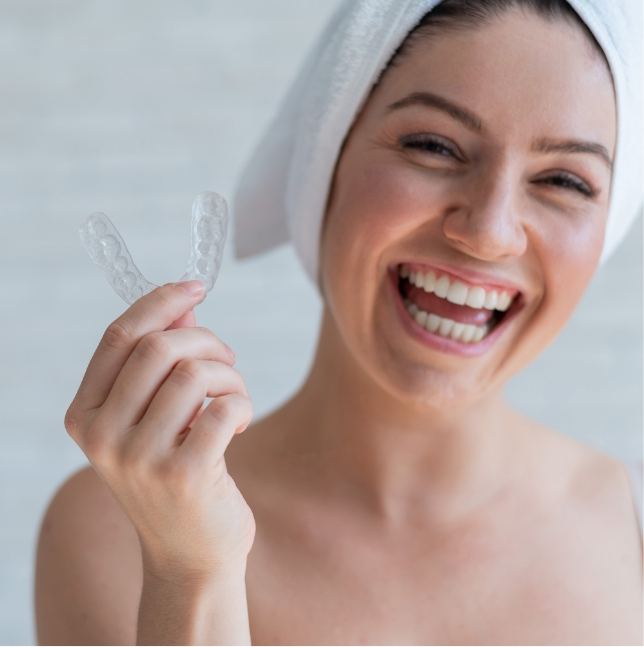 Smiling woman holding a nightguard